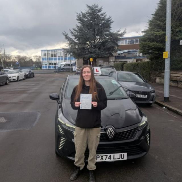 Pupil holding pass certificate in front of the lesson car
