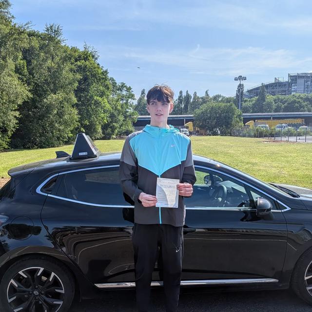 Pupil holding pass certificate beside the lesson car