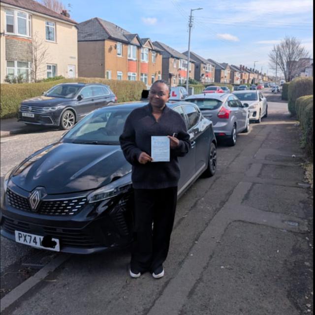 Pupil holding pass certificate beside the lesson car