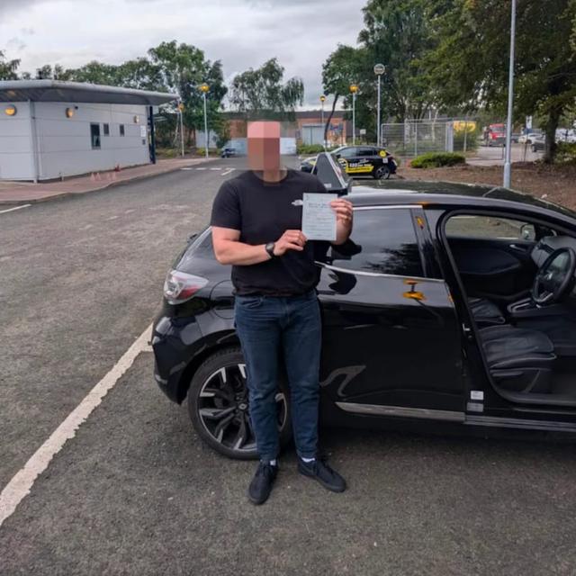 Pupil holding pass certificate beside the lesson car